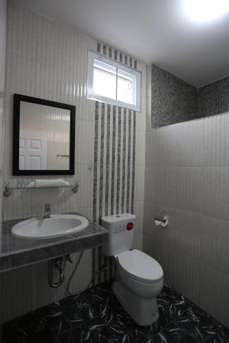 bagno con servizi igienici, lavandino e specchio di MB House Resort a Ban Nai Rai