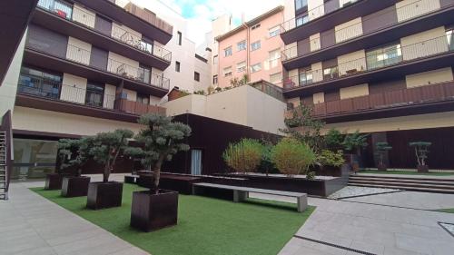 a courtyard with trees and benches in front of a building at LC Plaza del Pilar in Zaragoza