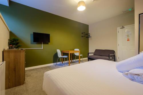 a bedroom with a bed and a desk and a tv at Station Lodge - FREE off-site Health Club access with Pool, Sauna, Steam Room & Gym in Windermere