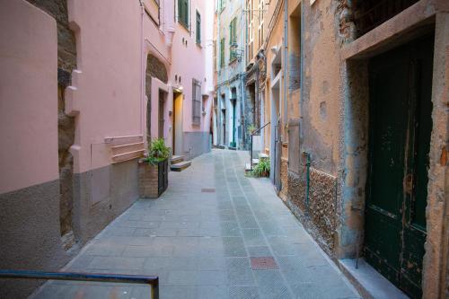an alley in an old town with pink buildings at The Vernazza Main Plaza - Rooms & Apartment in Vernazza
