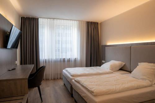 Cette chambre comprend un grand lit et un bureau. dans l'établissement Diamonds Hotel, à Cologne