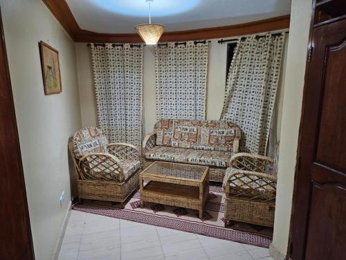 a living room with chairs and a couch and a table at Top of the World Lodges Fort Portal in Fort Portal