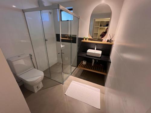 y baño con aseo, lavabo y espejo. en Nari Guest Room en Fernando de Noronha