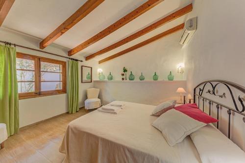 ポリェンサにあるVilla Can Salasのベッドルーム(緑のカーテン付きの白い大型ベッド1台付)