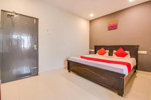 1 dormitorio con cama con almohadas rojas y ducha en OYO Flagship Our Palace en Gunadala