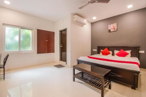 1 dormitorio con 1 cama grande con almohadas rojas en OYO Flagship Our Palace en Gunadala
