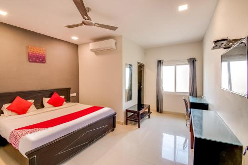 a bedroom with a bed with red pillows at OYO Flagship Our Palace in Gunadala