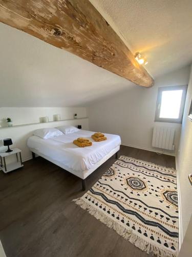 a bedroom with a white bed and a rug at Le Jaffa vue sur la Cité in Carcassonne