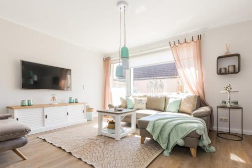 a living room with a couch and a tv at Strandlust in Zingst
