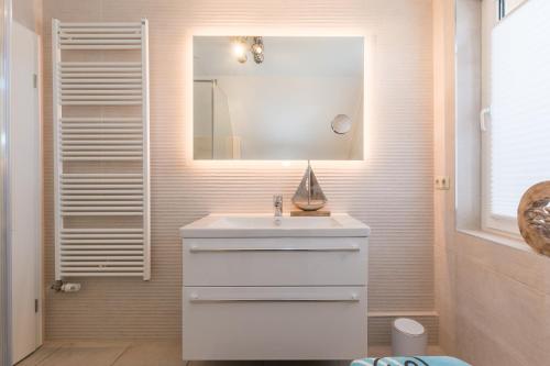 a bathroom with a white sink and a mirror at Strandlust in Zingst