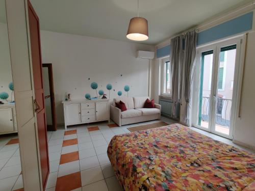 um quarto com uma cama e um sofá num quarto em Appartamento al mercato: Viareggio em Viareggio
