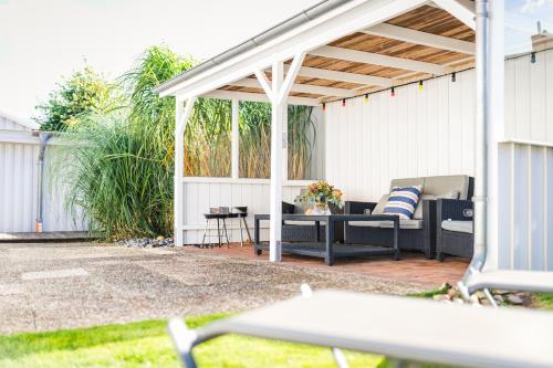 a white pergola with a table and chairs on a patio at Strandlust in Zingst