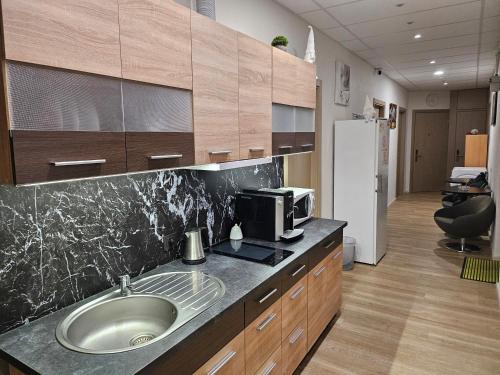 eine Küche mit einer Spüle und einer Mikrowelle in der Unterkunft Kambarys su balkonu ir didele lova Kauno centre #6 in Kaunas
