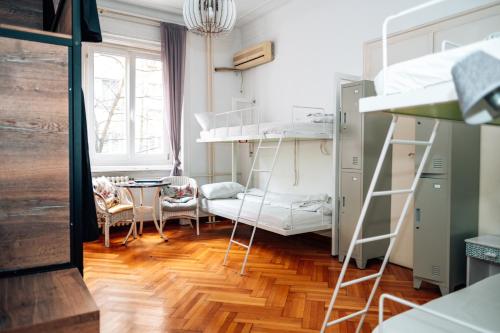 a room with two bunk beds and a table at Hostel Beogradjanka in Belgrade
