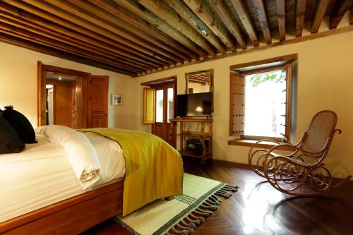 a bedroom with a bed and a chair and a television at Casa9 Zocalo in Mexico City