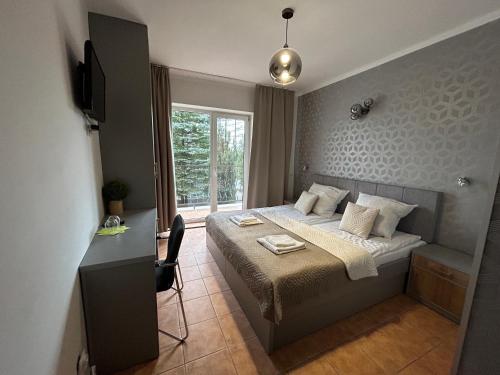 Habitación pequeña con cama y ventana en Gościniec nad Zalewem Sosina, en Jaworzno