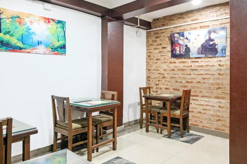 Habitación con 2 mesas, sillas y una pared de ladrillo. en City Star Hotel & Restaurant en Jawāharnagar