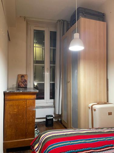 um quarto com uma cama, uma cómoda e uma janela em One-Bedroom Apartment by the Eiffel Tower: your home in the heart of Paris em Paris