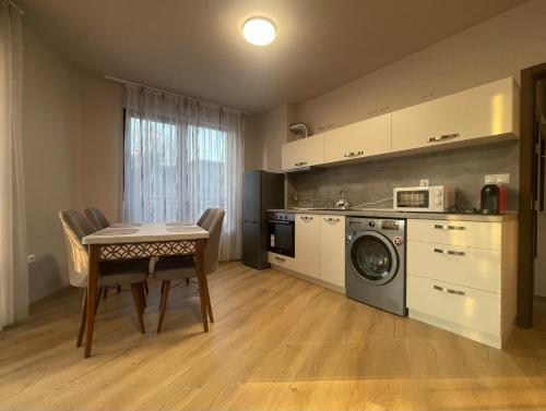 uma cozinha com uma mesa e uma máquina de lavar roupa em 3 стаен апартамент идеален център Варна em Varna City