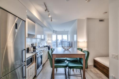 a kitchen with a table and chairs in a room at RivetStays - The Jarvis in Toronto