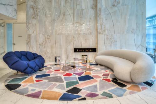 a lobby with two chairs and a rug at RivetStays - The Jarvis in Toronto