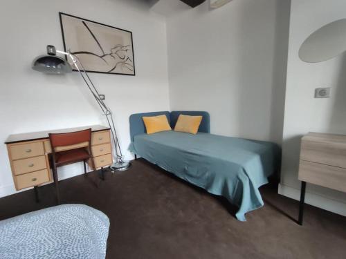 um quarto com uma cama, uma secretária e um candeeiro em Appartement 3 personnes quartier Chartrons em Bordeaux
