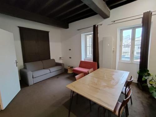 uma sala de estar com uma mesa e um sofá em Appartement 3 personnes quartier Chartrons em Bordeaux