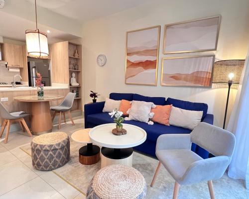 a living room with a blue couch and a table at Apartamento Punta Cana w/Pool & Beach in Punta Cana