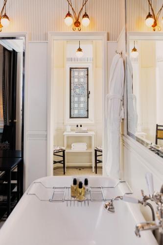 a white bathroom with a sink and a window at At Sloane in London