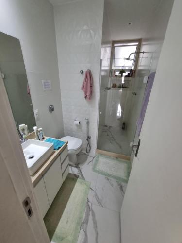 uma casa de banho com um chuveiro, um lavatório e um WC. em Quarto confortavel privativo Copacabana no Rio de Janeiro
