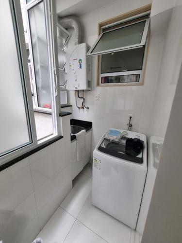 uma pequena cozinha com um frigorífico e uma janela em Quarto confortavel privativo Copacabana no Rio de Janeiro
