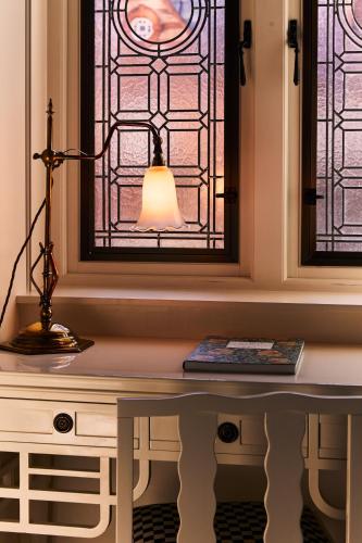 a lamp sitting on a desk in front of a window at At Sloane in London