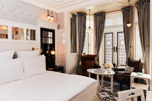 1 dormitorio con cama blanca y mesa en At Sloane en Londres