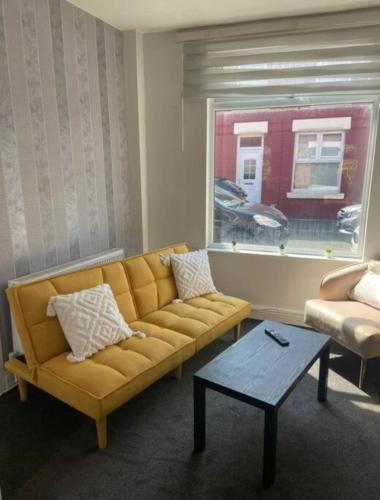 a living room with a couch and a window at Ideal for Contractors' Accommodation in Seacombe