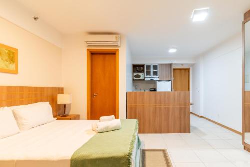 a bedroom with a large bed and a kitchen at BSB Stay Premium - Flats Particulares - SHN in Brasilia
