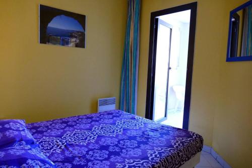 une chambre avec un lit violet et une fenêtre dans l'établissement Appartement coquet à Cannes avec piscine partagée / 40 m², à Cannes