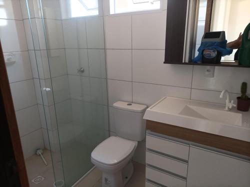 a bathroom with a toilet and a sink at Apartamentos Beira Mar in Laranjal