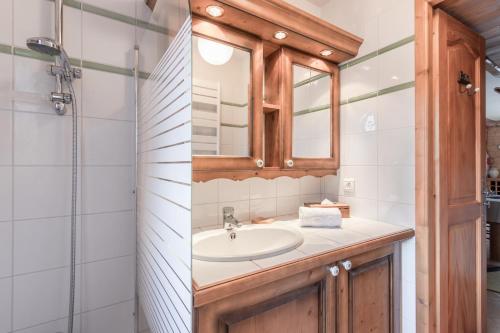 une salle de bain avec un lavabo et un miroir dans l'établissement Les Grandes Jorasses - Calme - Duplex, aux Houches