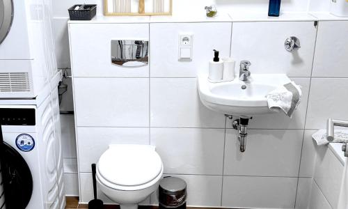 een witte badkamer met een toilet en een wastafel bij # VAZ Apartments SG01-02 ,WLAN,TV, Küche, Balkon, nahe Zentrum in Solingen