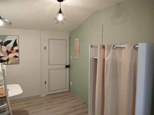 baño con cortina de ducha y puerta en Le Moulin Aux Ecrevisses, en Thonnance-lès-Joinville