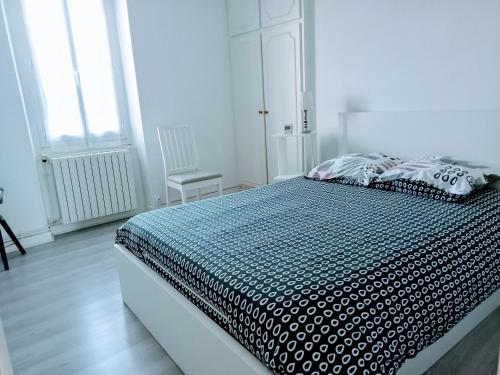 a bedroom with a bed with a black and white comforter at Le Patio in Villegailhenc