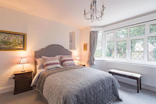 a bedroom with a bed and a large window at Yew Tree Cottage in Margate