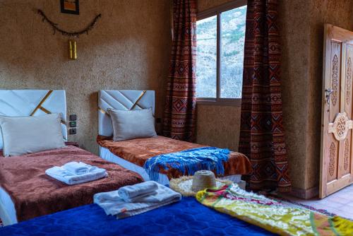 a room with two beds and a window at Atlas Views in Imlil