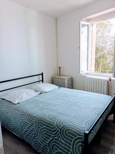 une chambre avec un lit et une fenêtre dans l'établissement Le Patio, à Villegailhenc