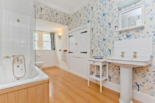 a bathroom with a tub and a sink and a toilet at Cairngorms Castle in Cray