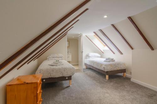 2 Betten in einem Dachzimmer mit Oberlichtern in der Unterkunft Cairngorms Cottage in Cray