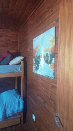 a room with a bed and a painting on the wall at Cabañas KAPO TEAM in Villa Amancay