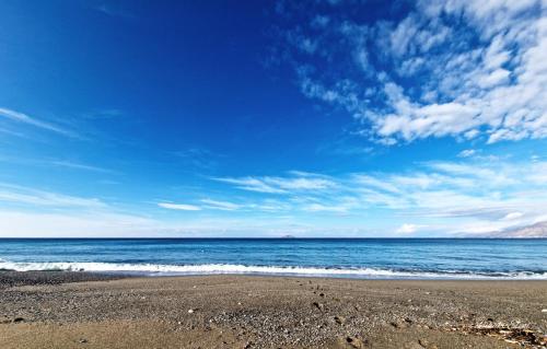 a beach with a blue sky and the ocean at ARTEMIS beach studios in Kalamaki