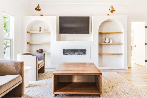 a living room with a fireplace and a table at LA Retreat: Stylish 3BR Villa in Los Angeles