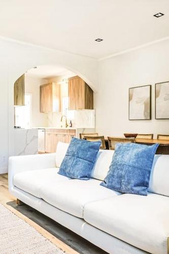 a white couch with blue pillows in a living room at LA Retreat: Stylish 3BR Villa in Los Angeles